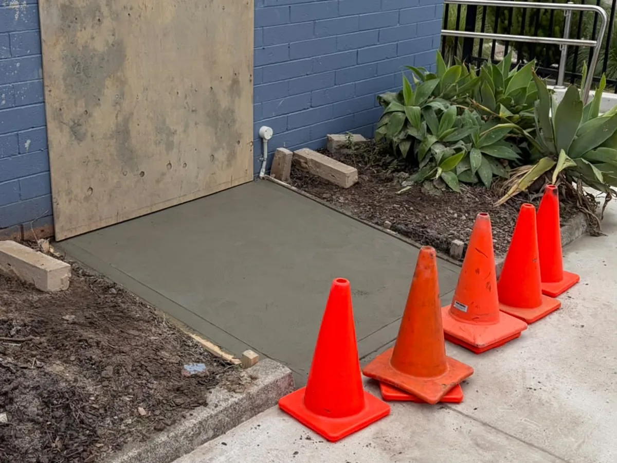 New concrete entry slab with traffic cones while it cures