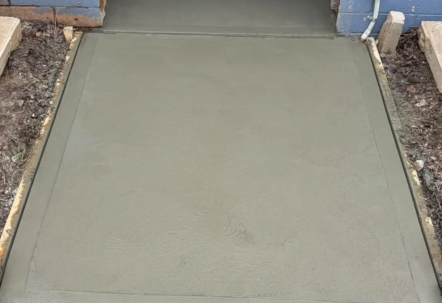 Freshly poured concrete slab at a commercial doorway