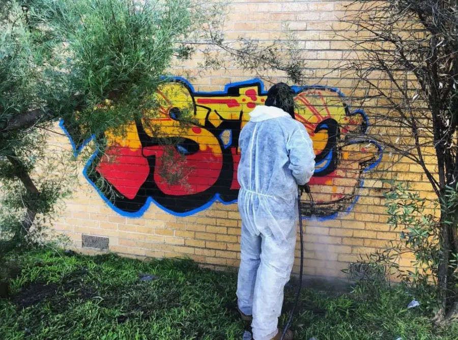 Commercial graffiti removal from a cream brick wall