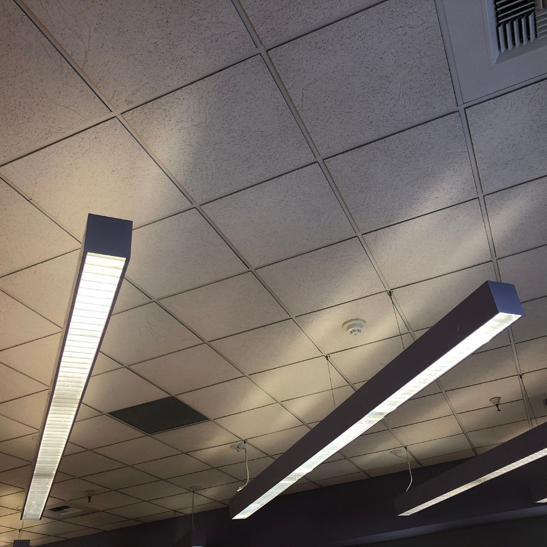 Commercial LED batten lighting on a tiled ceiling